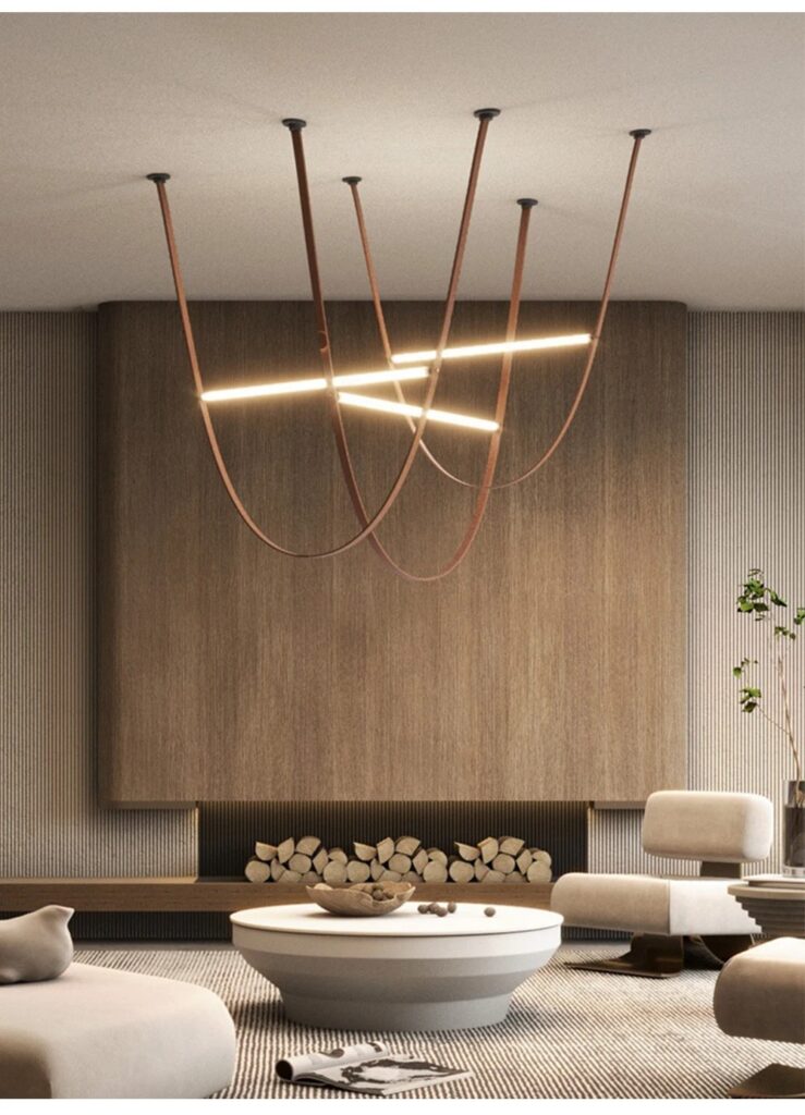 Unipenhas Designer U-Loops Leather Strap Pendant Light - A modern living room with a minimalist aesthetic. A unique leather strap chandelier hangs above a round coffee table, providing soft, ambient lighting. The chandelier features curved leather straps and integrated LED lights, creating a stylish and functional focal point.