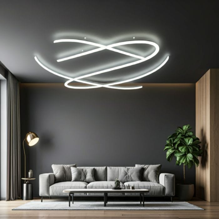 A modern living room with a sleek, curved LED ceiling light. The light creates a dramatic and eye-catching focal point in the room. The room features a gray wall, a comfortable gray sofa, a coffee table, and a potted plant.