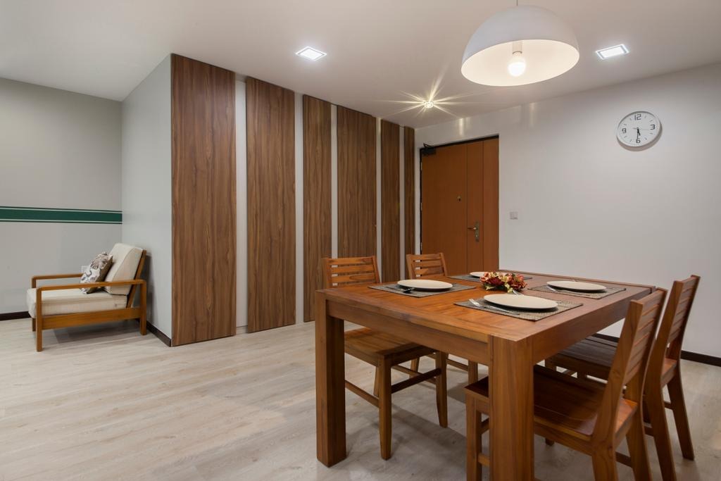 A cozy dining area with a wooden dining table and chairs. The room features warm, ambient lighting from recessed ceiling lights and a pendant light above the table. The overall aesthetic is warm and inviting.