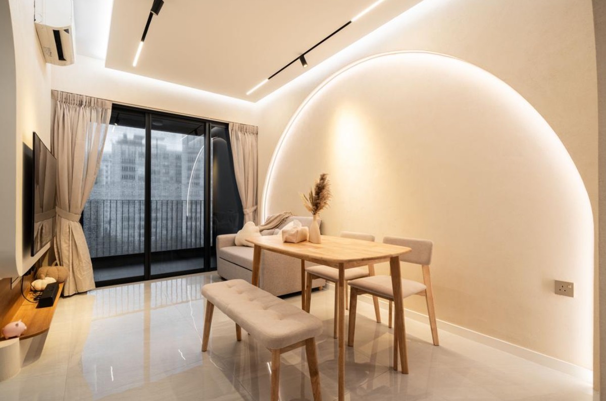 A modern living room with an arched wall feature creating a unique and inviting space. The room features a comfortable sofa, a dining table with chairs, and warm, neutral colors throughout.