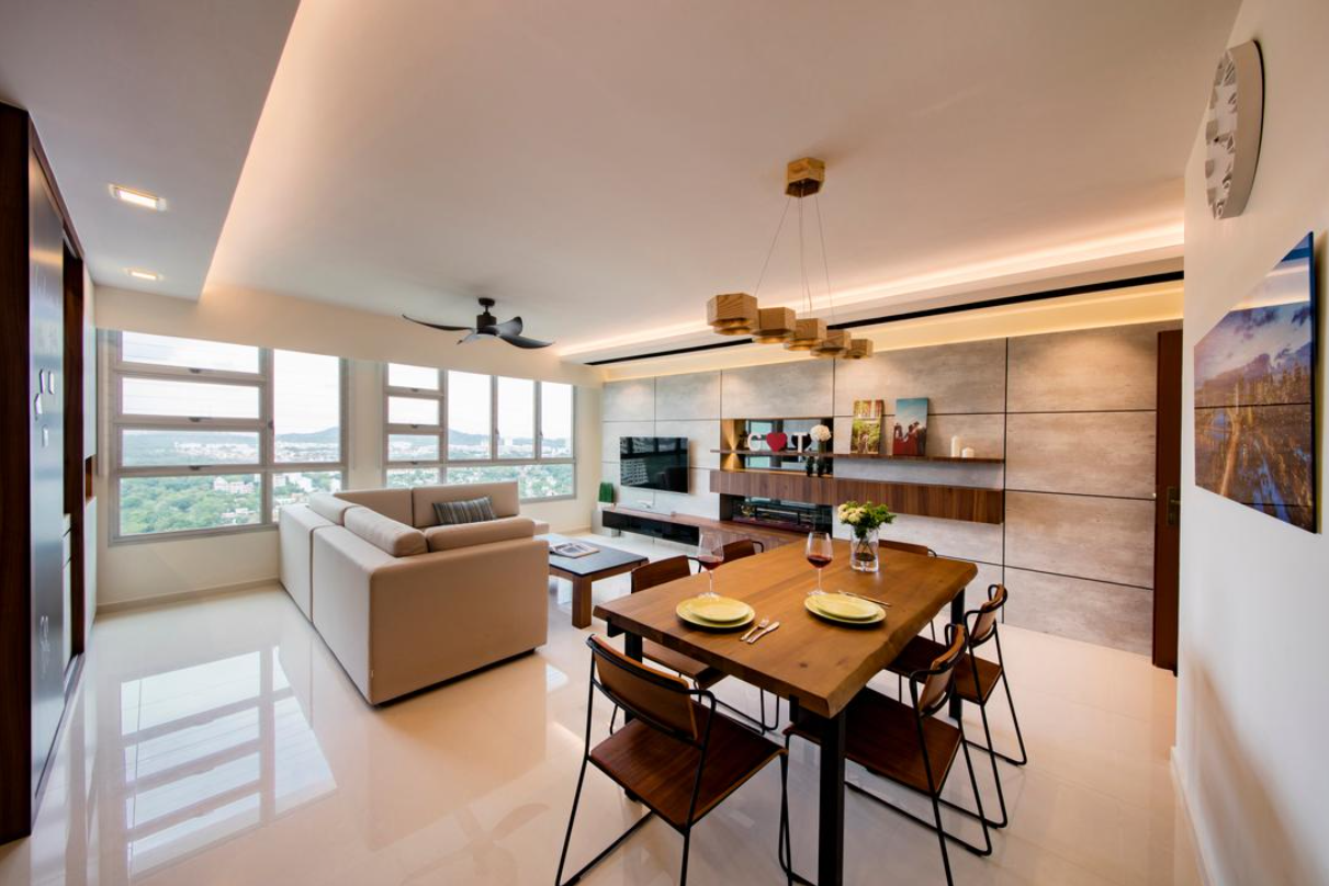 A modern open-concept living and dining room with a warm and inviting atmosphere. The space features a comfortable sofa, a wooden dining table, and a built-in entertainment center. The room is illuminated by a combination of recessed lighting, a ceiling fan with a light fixture, and a stylish pendant light above the dining table.