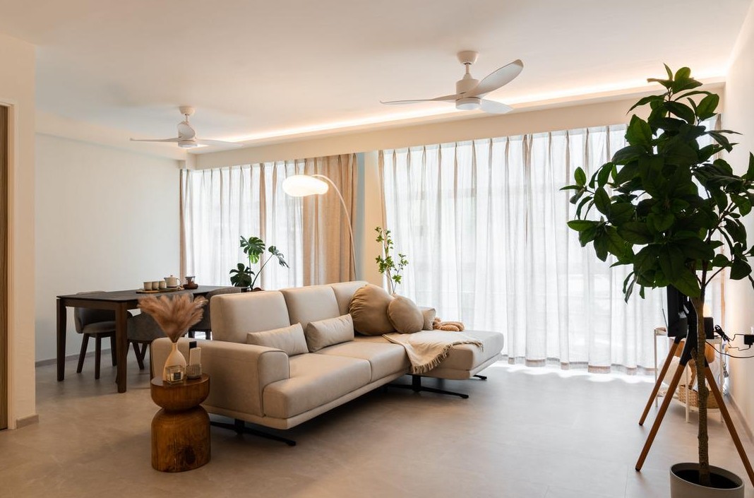 A serene living room with a neutral color palette and plenty of natural light. The room features a comfortable sofa, a dining table, and lush houseplants, creating a peaceful and inviting atmosphere.