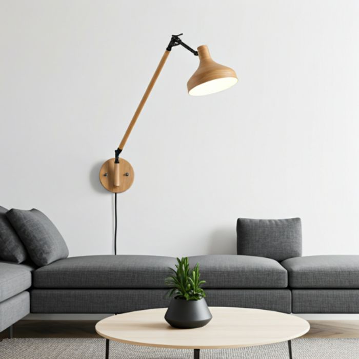 A modern living room with a wooden wall-mounted reading lamp extending over a gray sofa. The lamp features a long, flexible arm and a wide shade, providing focused light for reading or working.